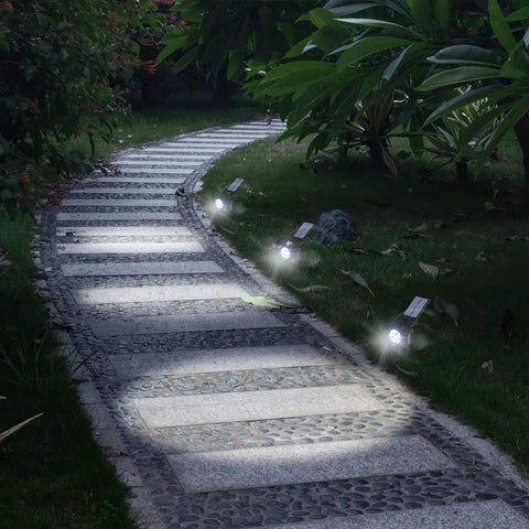 Ultra Bright Solar Spotlight 2 Pack with All Weather Waterproof Design casting light on a driveway at night