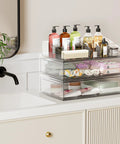Clear Acrylic Stackable Makeup Organizer With Drawer Elevates Your Vanity Routine, storing bottles and cosmetics on a bathroom counter.