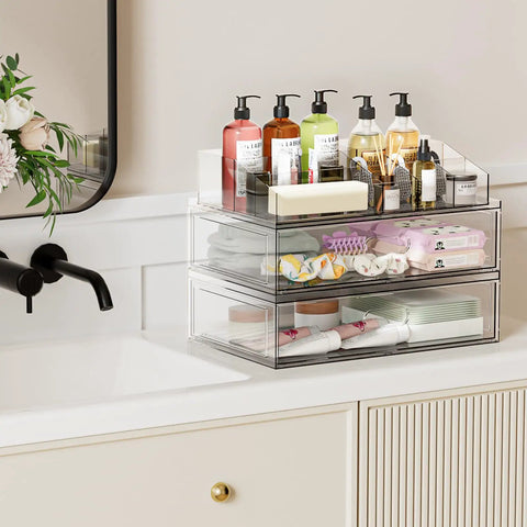 Clear Acrylic Stackable Makeup Organizer With Drawer Elevates Your Vanity Routine, storing bottles and cosmetics on a bathroom counter.