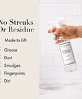 Hand holding Go-To All Purpose Surface Cleaner No 247 Scent 15.5 Fl Oz in front of checklist on tiled wall background.