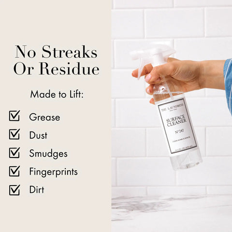 Hand holding Go-To All Purpose Surface Cleaner No 247 Scent 15.5 Fl Oz in front of checklist on tiled wall background.