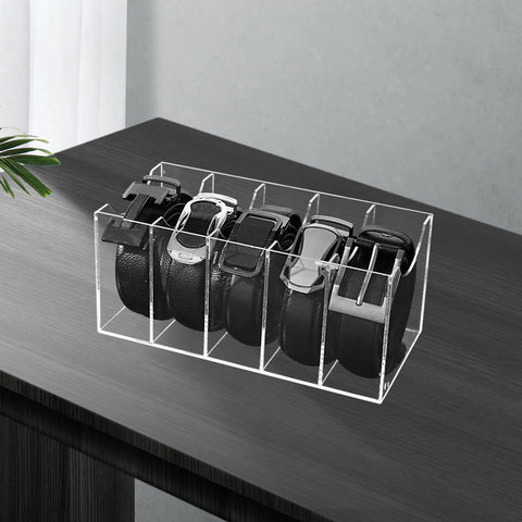 Upgrade Your Drawer Storage Vibe Today With This Sturdy Clear Acrylic Belt Organizer Designed With Five Flexible Foldable Sections To Store Ties And Belts on a wooden surface.