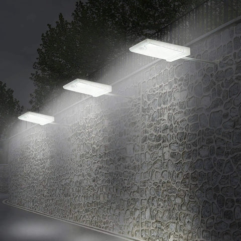 46 LED Solar Outdoor Lights With Mounting Pole 4 Modes Motion Sensor Wall Light illuminating stone wall at night