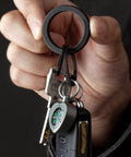 Hand holding Black Titanium Key Ring With Innovative Side Push Pump Design, Heavy Duty Keychain Accessory For Fast One Handed Ring Swaps