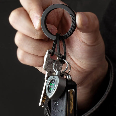 Hand holding Black Titanium Key Ring With Innovative Side Push Pump Design, Heavy Duty Keychain Accessory For Fast One Handed Ring Swaps