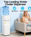 Hot And Cold Water Cooler Dispenser For 5 Gallon Bottle With Top Loading Design next to woman on sofa