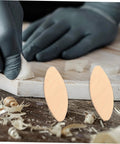 100 PC Wood Biscuits For Woodworking Pro Grade Slotting And Plywood Joinery Tool on wood surface with gloved hand detailing