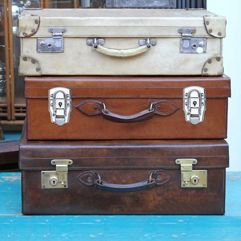 Stack of vintage leather suitcases with metal locks, displaying secure latching solutions for gear protection.