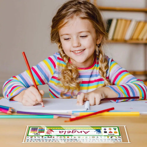 Child writing at desk with 36 Pieces Clear Nameplate Pocket Self Adhesive Desk Name Tag Covers for School Classrooms and Offices, 13.5 x 4.9 Inches, Upgraded Transparent Name Plate Holder, Fits Standard Name Tags, No Tags Included.
