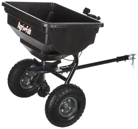 Tow Behind Lawn Spreader With 85Lb Rustproof Poly Hopper And Spreader Plate, black design with pneumatic tires, side view