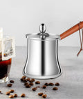 Stainless Steel Turkish Coffee Pot And Melt Pan For Butter Sauces And Frothing Milk 720ml with wooden handle on a table.