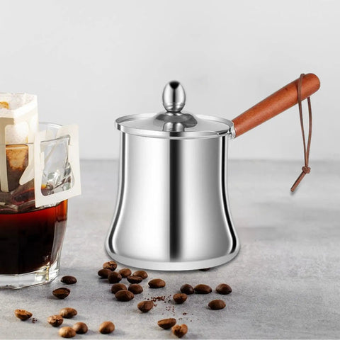 Stainless Steel Turkish Coffee Pot And Melt Pan For Butter Sauces And Frothing Milk 720ml with wooden handle on a table.