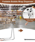 Foldable bubble wrap dispenser shown in a warehouse, supporting Heavy Duty Bubble Cushioning Wrap Stand With Precise Tension Control.
