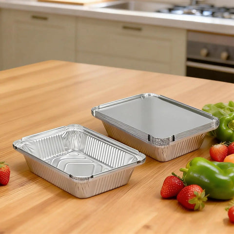 60 Pack Aluminum Foil Pans With Lids, 8.5 By 6 Inch, 2.25 Lb Capacity, placed on kitchen counter with fresh vegetables