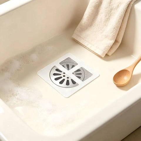 Hair Drain Stickers 100 Pcs Disposable Peel Stick placed in a sink with bubble bath, featuring a black mesh design.