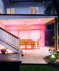 Covered patio with pink-lit seating area using Crazy Bright Supercolor BR30 Smart Flood Bulbs 2 Pack RGB Plus Tunable White, 1100 Lumens