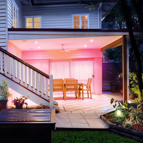 Covered patio with pink-lit seating area using Crazy Bright Supercolor BR30 Smart Flood Bulbs 2 Pack RGB Plus Tunable White, 1100 Lumens