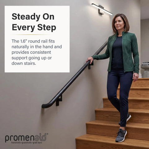 Woman holding Ultra Slick Satin Black 1.5ft ADA Handrail Kit on wooden stairs indoors.