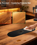 Person cleaning Sliding Pad For Single Serve Coffee Makers PB051 PB041 Smooth Glide Espresso Mat Countertop Protector on wood surface.