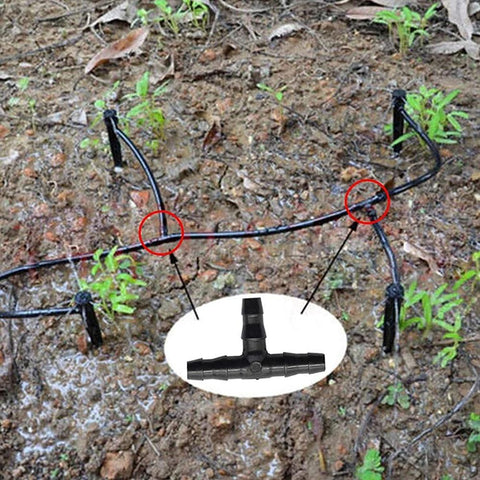 Irrigation barbed fittings kit for 1/4in tubing; black plastic tubing laid in garden; inset shows T-fitting.
