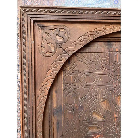 Close-up of hand-carved design on custom solid wood barn door, rustic Moroccan inspired, 71x34 inches, no glass or hardware included.