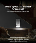 GuideLight Duplex Outlet Night Light With LED Sensor glowing on wall under stairs, two dogs sleeping nearby, grey wall background