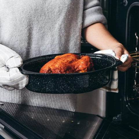 Person holding an Oval 13 Inch Roaster With Lid Enameled Steel Pan That Holds Up To 7 Lb Poultry Or Roast Heat Resistant To 932 Degrees Fahrenheit