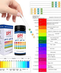 Hand holding Easy Read pH Test Strips For Urine, Saliva, And Water 0 To 14 Universal Plastic Strips with color chart