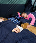 Children and a dog sleeping in a Double Sleeping Bag For Camping And Backpacking, Queen Size Two Person, with flannel lining and 3D fill.