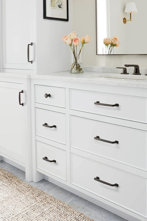 Kick Your Cabinetry Up A Notch With This Slick 1 3/16 Inch Round Cabinet Knob In Premium Black Bronze Finish on white kitchen drawers.