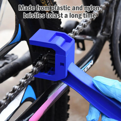 Blue brush from the Bike And Motorcycle Chain Cleaning Brush Set Blue And Red Dual Color 10 Inch Total Length Multi Purpose Chain Maintenance Tool For Easy Chain Wash And Smooth Ride being used on a bike chain.