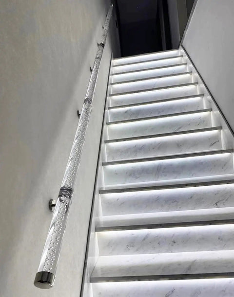 Built Like A Tank Clear Acrylic Stair Railing Kit With Heavy Duty Silver Brackets installed along illuminated staircase for safety.