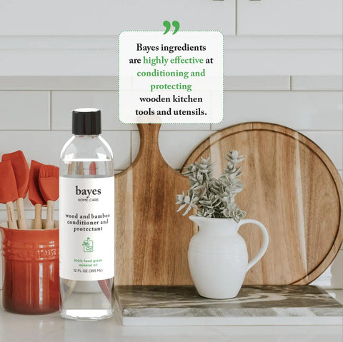Food Grade Mineral Oil For Cutting Boards And Wood Conditioners Protectant For Bamboo Teak And Other Wood Kitchen Utensils, 8 oz bottle on counter with cutting boards and utensils.