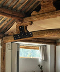 Kickass T Shape Metal Post Brackets 4 Pack With Screws Heavy Duty steel bracket mounted on wooden beams in a rustic interior.
