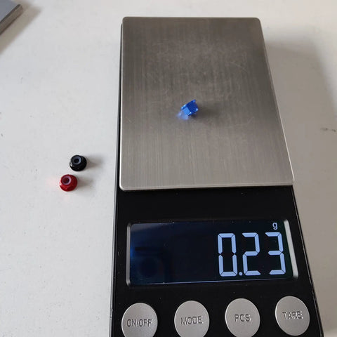 30 Count Kickass M3 Flange Lock Nuts With Nylon Insert Aluminum Alloy on scale, measuring weight at 0.23g, showing colors.