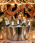 Party scene with Hammered Stainless Steel Beverage Tub With Double Walled Insulation Anchored Ice Bucket Chiller For Epic Parties 12 Quarts with bottles and ice