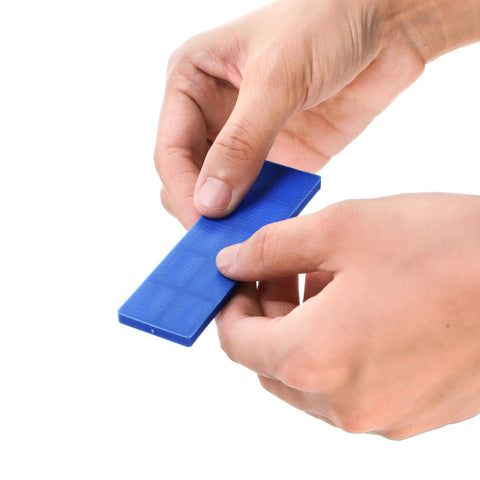 Okllen plastic flat shim, blue, held by hands (front view)