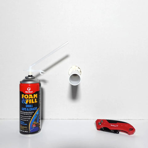 Heavy Lifters Expanding Spray Foam Sealant Fills Gaps And Cracks Straight Up, 12 Oz tube next to foam-filled pipe fitting.