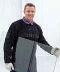 Cowhide Welding Cape Jacket Built Like A Tank Featuring Full Cape Sleeves Anchored To A Heavy Duty Bib Apron For Top Tier Heat And Spark Shielding In Pitch Black, worn by a man holding glass.