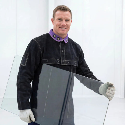 Cowhide Welding Cape Jacket Built Like A Tank Featuring Full Cape Sleeves Anchored To A Heavy Duty Bib Apron For Top Tier Heat And Spark Shielding In Pitch Black, worn by a man holding glass.