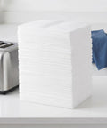 Stack of white heavy duty foam cushion pouches for dishes and glassware next to toaster on kitchen counter