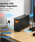 Rock Solid 1500VA 800W UPS Battery Backup And Surge Protector with LCD display alongside PC and router on desk.