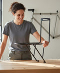 Person examining a front fork rack for bikepackers and commuters, lightweight and sturdy cargo carrier built from steel or aluminum.