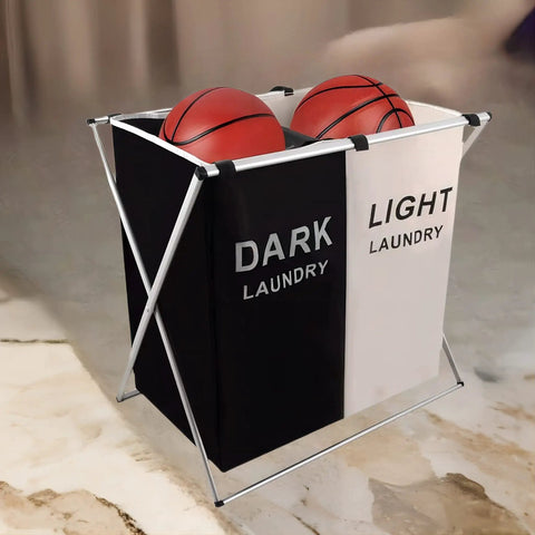 Two Section Laundry Basket With Foldable Design holding basketballs, featuring black and white sections and aluminum frame.