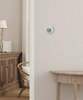 Round No Frills Non Programmable Manual Thermostat With Easy Dial Control on white residential wall, view from hallway