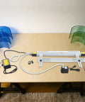 24 Inch 1000W Acrylic Heat Bending Machine With Water Cooling For Plexiglass Plastic setup with blue and green sheets on a workbench.