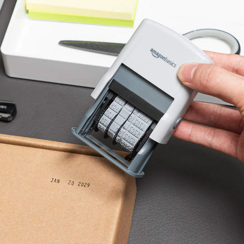 Heavy Duty Self Inking Date Stamp For Office Documents Legal Papers And Corporate Mail Featuring Bold Saturation Marks and a Flexible Ten Year Setting held over a package with date mark.