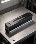 Micpointik 100mm Strip Level 0.02mm, Metal Machinist on workbench with a metal surface for precision alignment.
