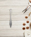 Straight Up Precision Leather Marking Divider And Adjustable Stainless Steel Wing Creaser on wooden surface with buttons and scissors.
