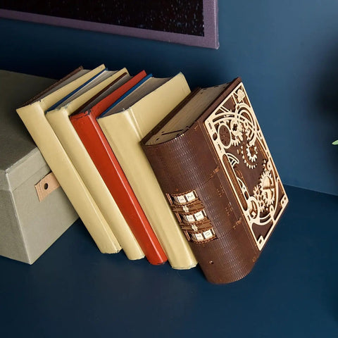Book Of Secrets Steampunk 3D Puzzle Kit For Adults With Hidden Gears wooden model resembling a book on blue shelf